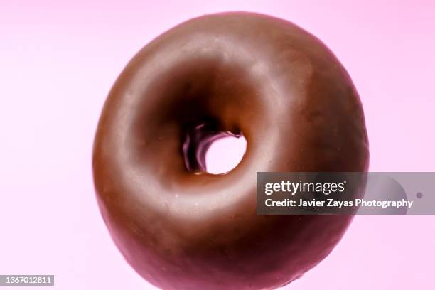 chocolate doughnut on pink colored background - チョコレートケーキ ストックフォトと画像