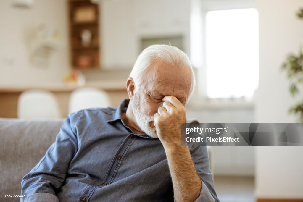 Senior Man Suffering From Headache at Home