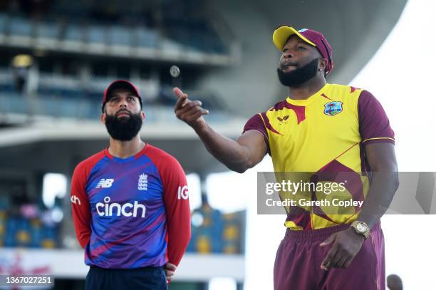 Kieron Pollard of West Indies flips the coin as Moeen Ali of England looks on ahead of the T20 International Series Third T20I match between the West...