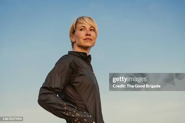 portrait of beautiful woman standing against blue sky - vista de ángulo bajo fotografías e imágenes de stock