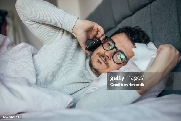 kranker mann, der telefoniert, wenn er im bett liegt - sleep female handphone stock-fotos und bilder