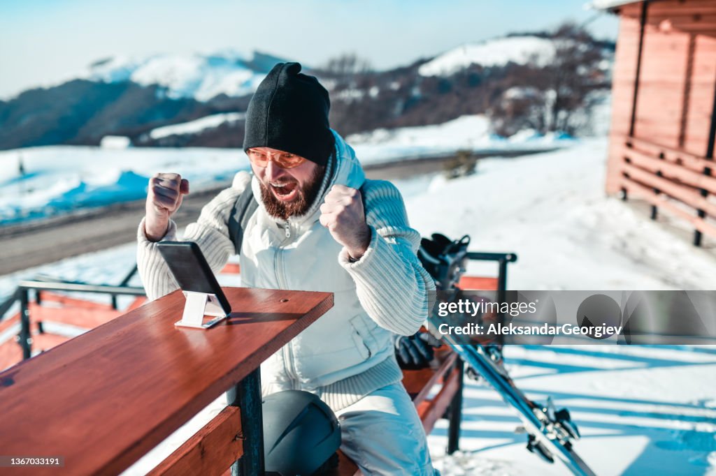 Bearded Male Neglecting Skiing Time While Playing Poker On Smartphone
