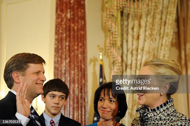 Secretary of State Hillary Clinton gives the oath of office to Ambassador-Designate to Russia Michael McFaul as his wife Donna Norton looks on at the...