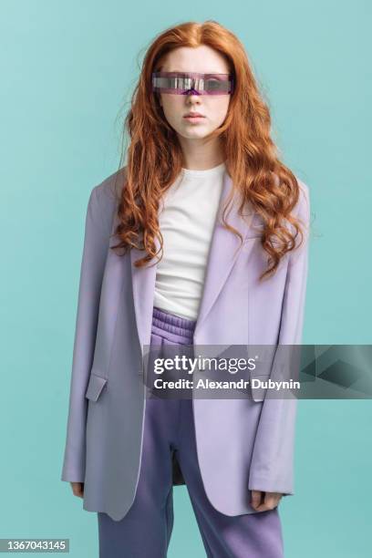 beautiful young red-haired model posing in the studio wearing trendy virtual reality glasses. beauty and technology concept - 3d modeling stockfoto's en -beelden