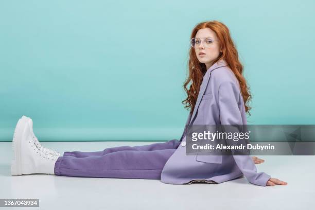 fashion model woman posing sitting in the studio in a new collection of colorful clothes. fashion and beauty concept - business model stock-fotos und bilder