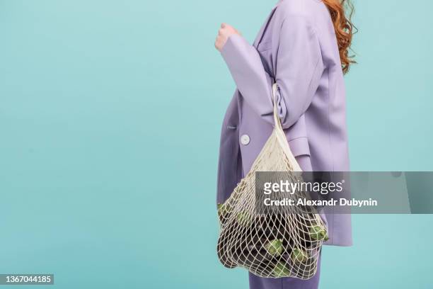 woman with a shopping bag with eco products vegetables eggplant on a colored background - beautiful food stock-fotos und bilder