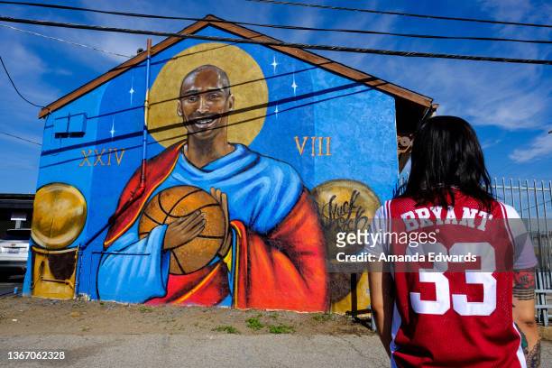 Basketball player and coach Ayleen Enriquez pauses for a moment of reflection in front of a mural painted by Jules Muck on the second anniversary of...