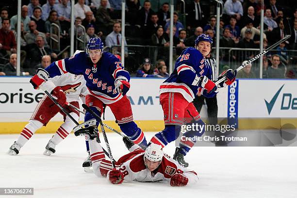 Lauri Korpikoski of the Phoenix Coyotes falls to the ice after a challenge from Ryan McDonagh of the New York Rangers and Ruslan Fedotenko of the New...