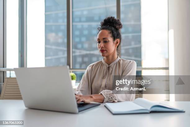 latina mid adult female typing while educating online - online seminar stock pictures, royalty-free photos & images