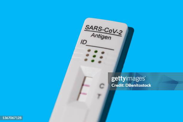 detail of an antigen test with two red lines, giving a positive result for covid-19, on a blue background. coronavirus concept, antigen test, omicron, delta, ihu and deltacron. - coronavirus test foto e immagini stock