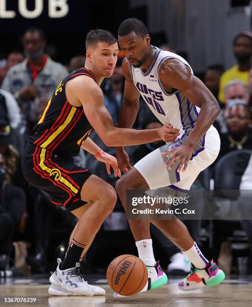 Harrison Barnes of the Sacramento Kings loses the ball as he is defended by Bogdan Bogdanovic of the Atlanta Hawks during the second half at State...