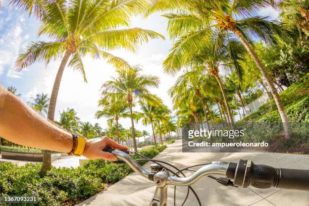 サウスビーチ、マイアミビーチ、マイアミ、南フロリダ、アメリカのサウスポイントパークで自転車に乗っている若いスポーツマンのpovポイントショット - miami beach ストックフォトと画像