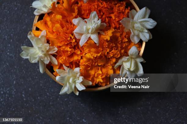 marigold  and jasmine flowers in a brass urli/vessel/flower decoration - onam foto e immagini stock