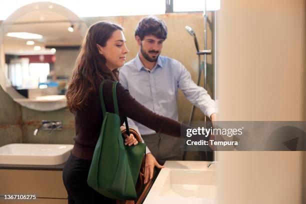 a couple is choosing faucets for their new home. - utställare bildbanksfoton och bilder