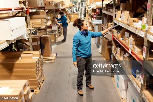 A Warehouse worker uses a barcode reader in the storage room.