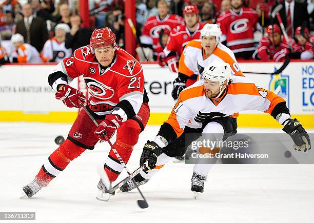 Alexei Ponikarovsky of the Carolina Hurricanes moves the puck up the ice under pressure from Andrej Meszaros of the Philadelphia Flyers during play...