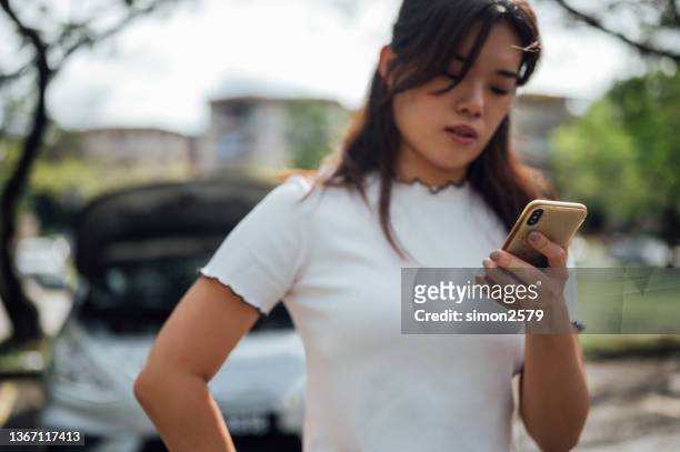 young asian woman waits for assistance near her car broken down on the road side - overheated stock pictures, royalty-free photos & images