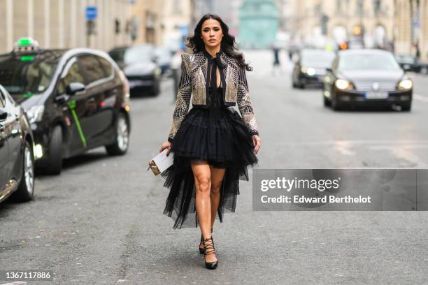 Leila Ben Khalifa wears a black with embroidered gold sequined cropped jacket with shoulder-pads, a black tulle polka dots print pattern cut-out neck...