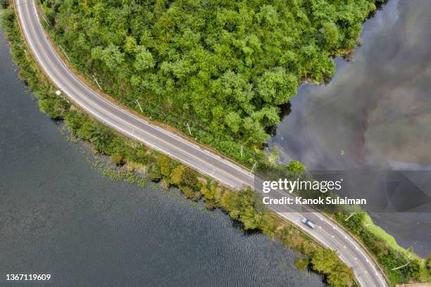 aerial view of road above a lake - wilderness road stock pictures, royalty-free photos & images