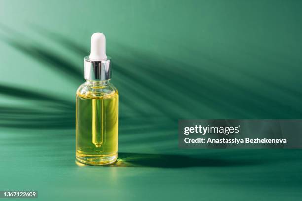 glass bottle with pipette against green background - kazakhstan oil stock pictures, royalty-free photos & images
