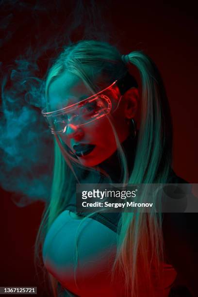 futuristic woman with smoke against dark red background - schwache beleuchtung stock-fotos und bilder