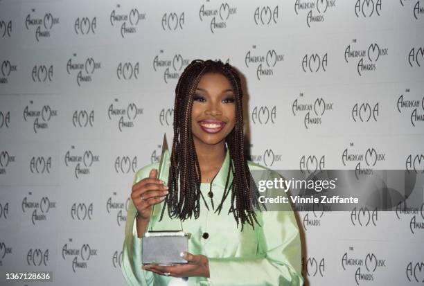 American singer, songwriter, and actress Brandy, wearing a pale green suit, in the press room of the 23rd Annual American Music Awards, held at the...