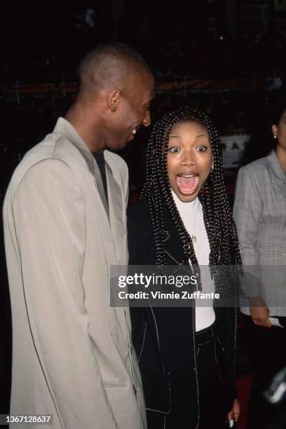 American basketball player Kobe Bryant and American singer, songwriter, and actress Brandy attend the Hollywood premiere of 'Eraser,' held at Mann's...
