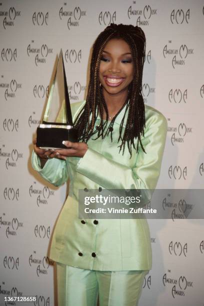 American singer, songwriter, and actress Brandy, wearing a pale green suit, in the press room of the 23rd Annual American Music Awards, held at the...