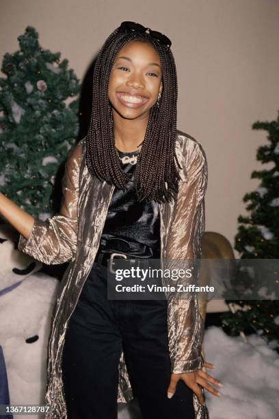 American singer, songwriter, and actress Brandy, wearing a gold jacket and black trousers, attends the 64th Annual Hollywood Christmas Parade at KTLA...