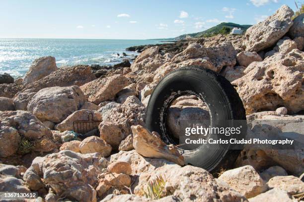 old abandoned car tire in the mediterranean coast - autoreifen natur stock-fotos und bilder