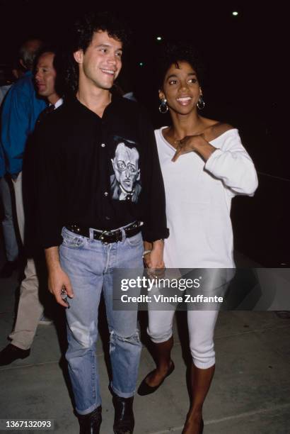 American actor Brian Robbins, wearing a black shirt and jeans, and American actress Holly Robinson, wearing a white sweater and white leggings,...