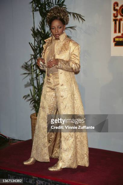 American singer and songwriter Mary J Blige, wearing a gold outfit with a gold coat, in the press room of the 11th Soul Train Music Awards, held at...