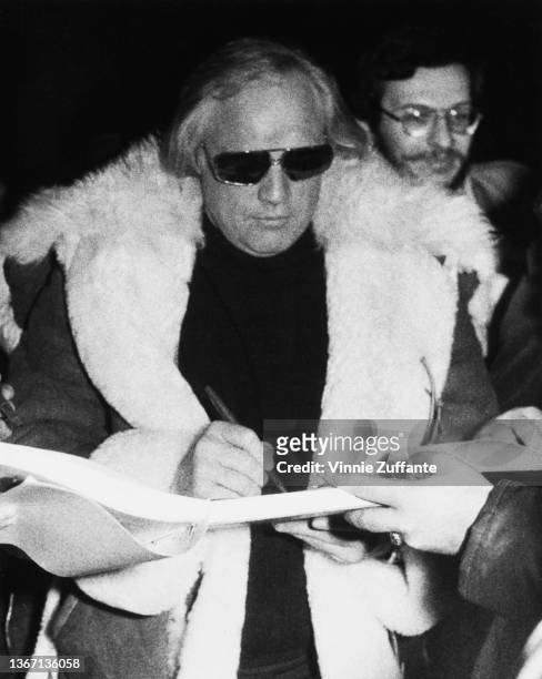 American actor Marlon Brando signs autographs for fans as he arrives for his appearance on 'The Tomorrow Show,' at the NBC studios in the RCA...