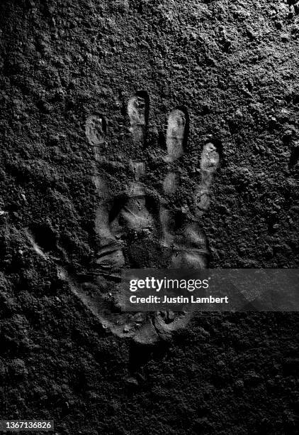 hand print in carbon powder shot overhead carbon footprint or hand on moon - stone hand stock-fotos und bilder