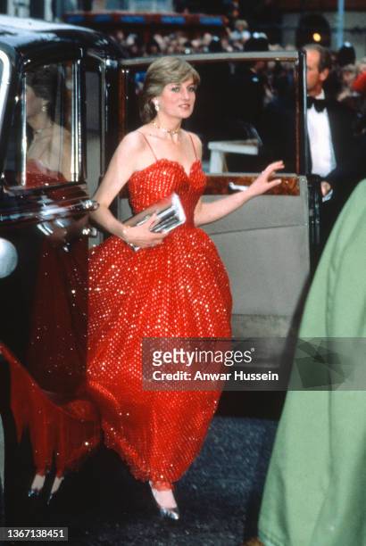 Lady Diana Spencer, wearing a red and gold spangled chiffon gown designed by Bellville Sassoon, arrives to attend the premiere of the James Bond film...