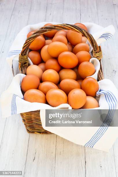 brown organic eggs in a basket - eggs in basket stockfoto's en -beelden