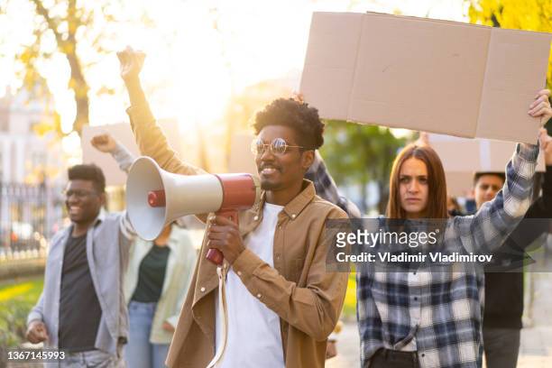 students demonstrating with blank placards - protestor megaphone stock pictures, royalty-free photos & images