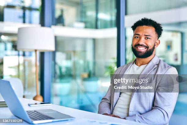 shot of a young businessman using a laptop in a modern office at work - bring your own device stockfoto's en -beelden