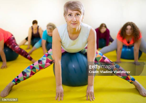 elegant postures in a pilates class - legs apart stock pictures, royalty-free photos & images