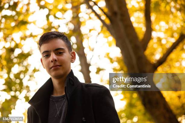 porträt eines 15-jährigen kaukasischen teenagers, der an sonnigen herbsttagen auf der straße gähnt - 16 17 years stock-fotos und bilder