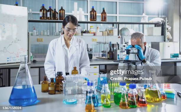 two microbiologists working on medical research in a laboratory - virology stockfoto's en -beelden