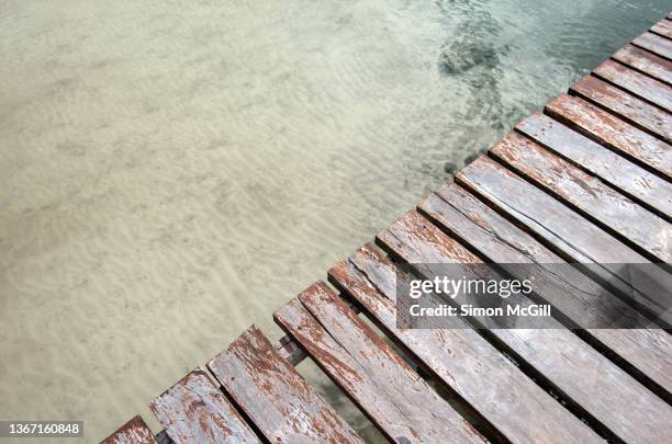 sun-bleached wooden boards of a jetty and the shallow sea - ponton bois photos et images de collection