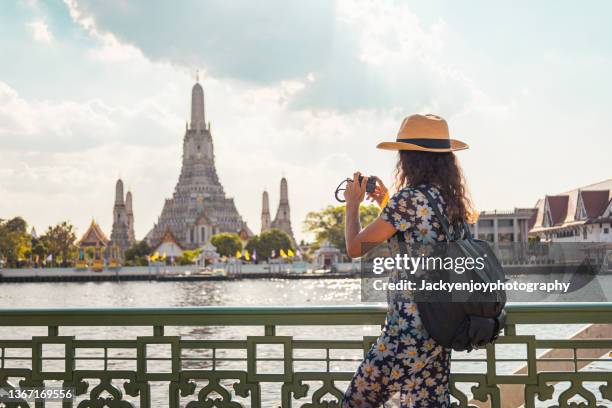 young woman holding a camera and taking photos in thailand - bangkok imagens e fotografias de stock