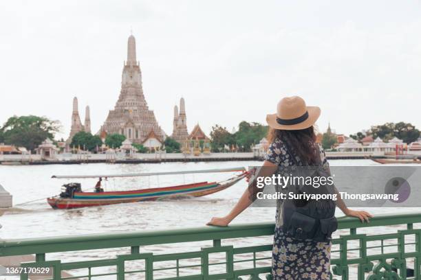 young women tourist impressive in beautiful temple at wat arun which alongside chao phraya river on holiday in bangkok, thailand. - grand palace bangkok stock pictures, royalty-free photos & images