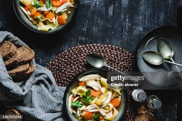 gesunde hühnerei-nudelsuppe auf der küchentheke serviert - soup vegtables stock-fotos und bilder