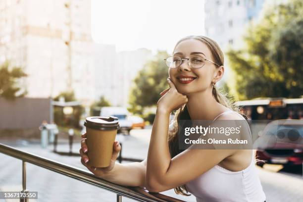 young woman leaning on railing with coffee cup. - bus side view stock pictures, royalty-free photos & images