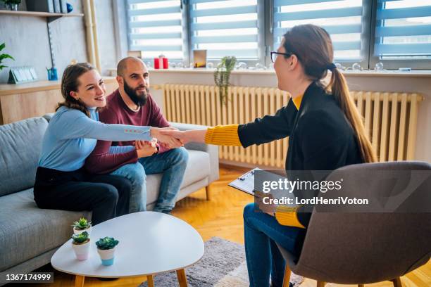 thankful couple at a marriage therapist - couple shaking hands with doctor stock pictures, royalty-free photos & images