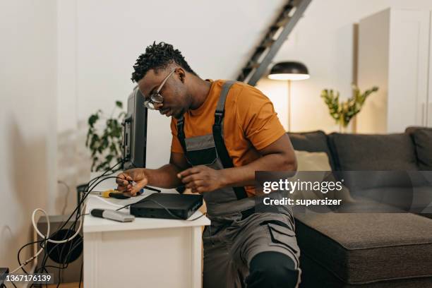young handyman fixes cable tv - telephone line stock pictures, royalty-free photos & images