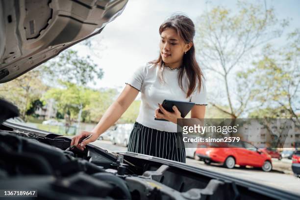 an asian insurance adjuster inspecting damage to vehicle - damaged car stock pictures, royalty-free photos & images