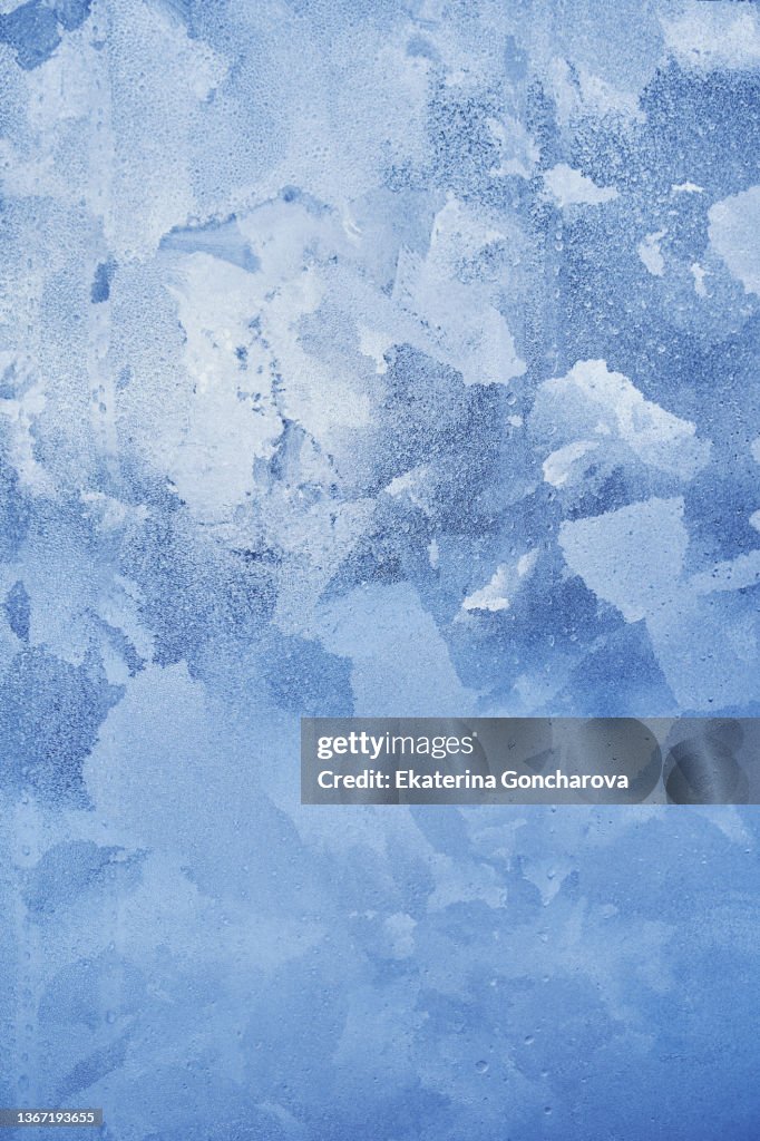 Abstract blue background of ice, frozen glass.